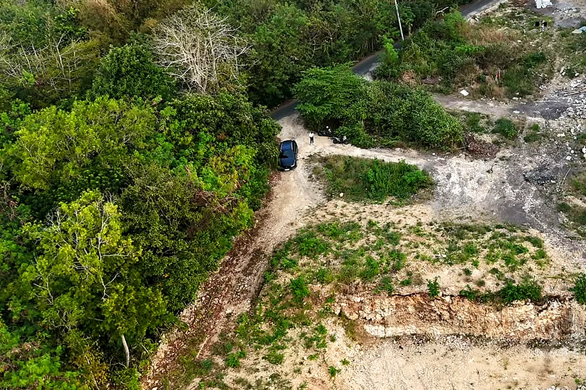 Aerial view of a cleared limestone building plot in Uluwatu, access track and a neighbouring villa under construction