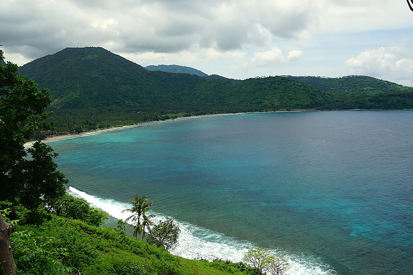 Baie turquoise sous des collines vertes sur la côte ouest de Lombok, près de Senggigi
