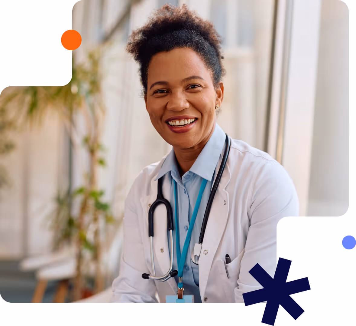 Smiling female doctor wearing a white coat and stethoscope in a bright medical office.