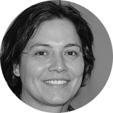 Black and white close-up portrait of a smiling woman with dark hair.