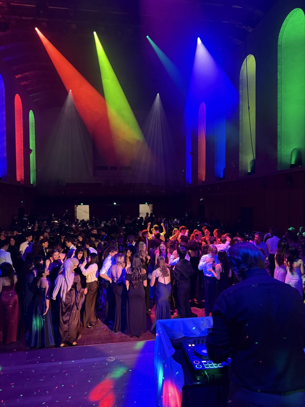 Packed dance floor under moving-head lighting at a university ball in Winthrop Hall, UWA, Perth