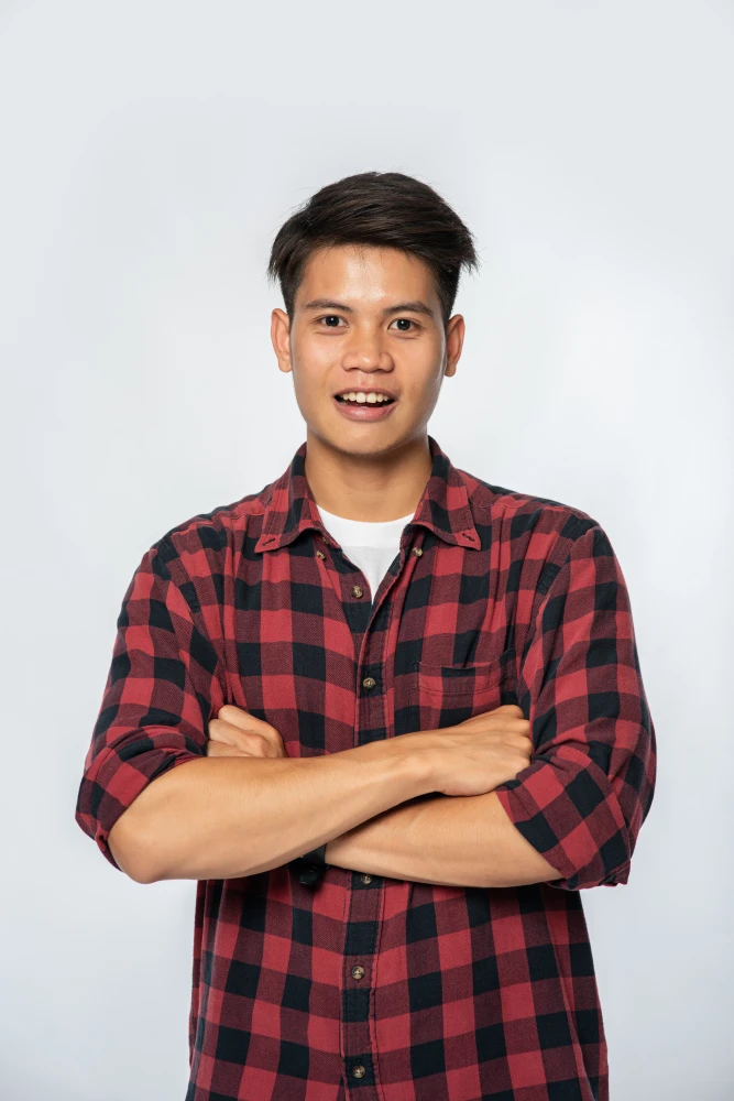 Portrait of young man in red plaid shirt with confident pose.