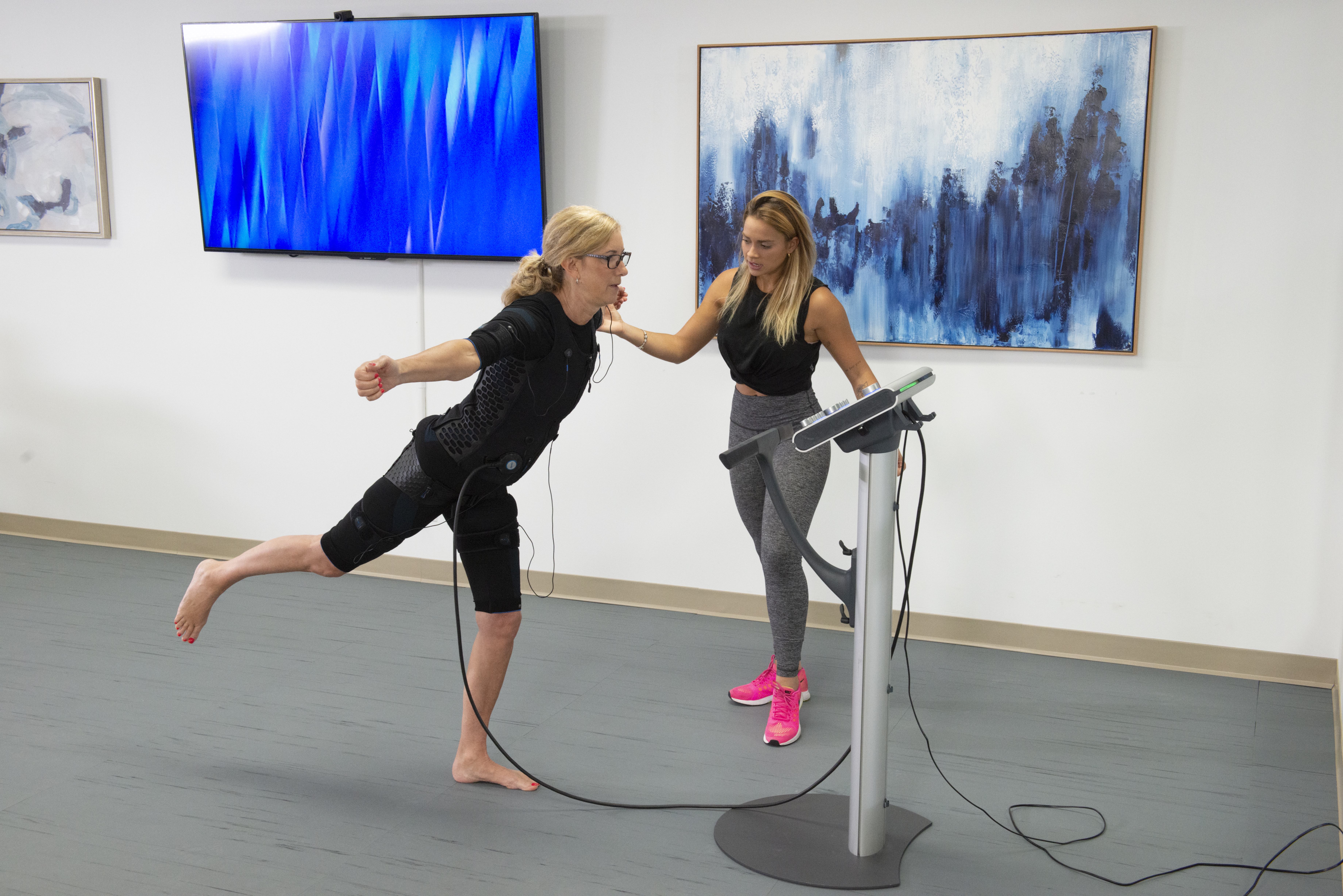 EMS trainer guiding a client through a balance exercise at Intelligent Therapy