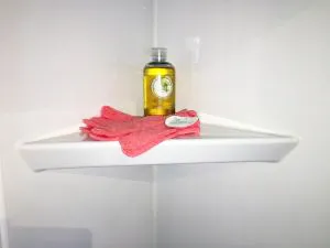 Corner shelf for an acrylic shower