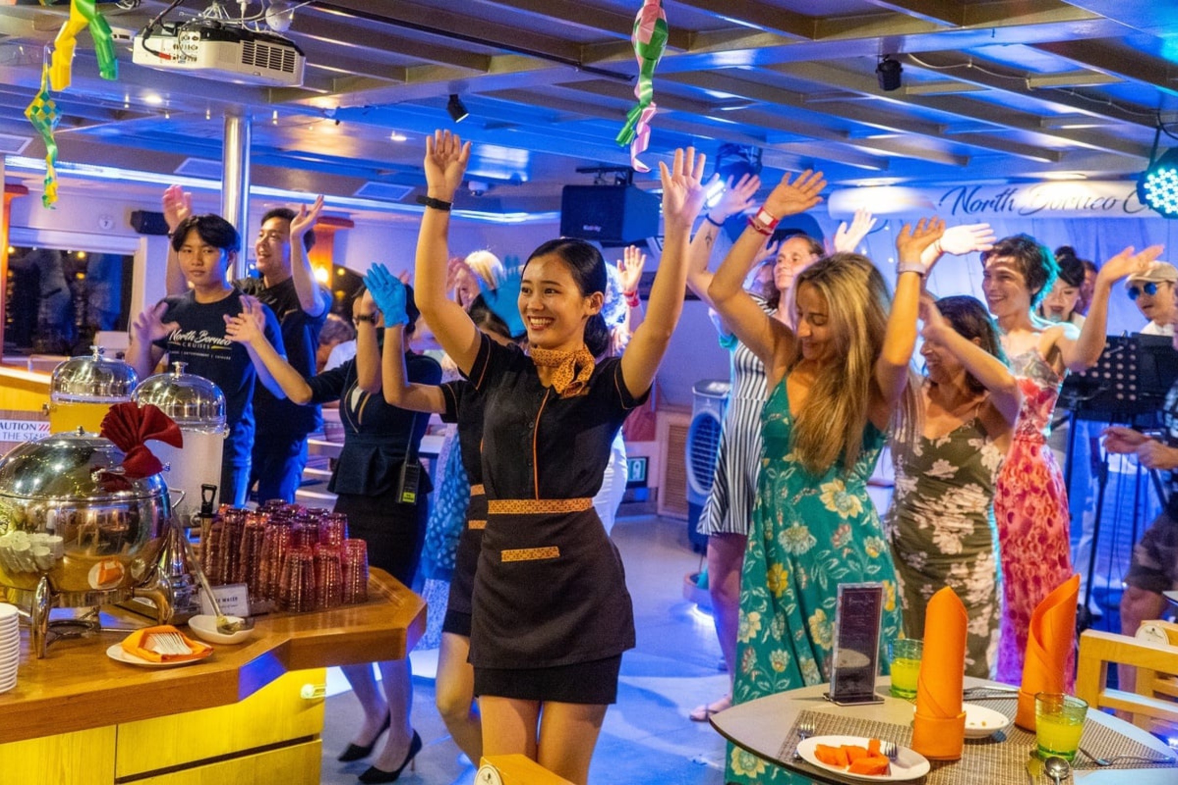 NBC crews dancing joyfully with guests inside NBC cruise.