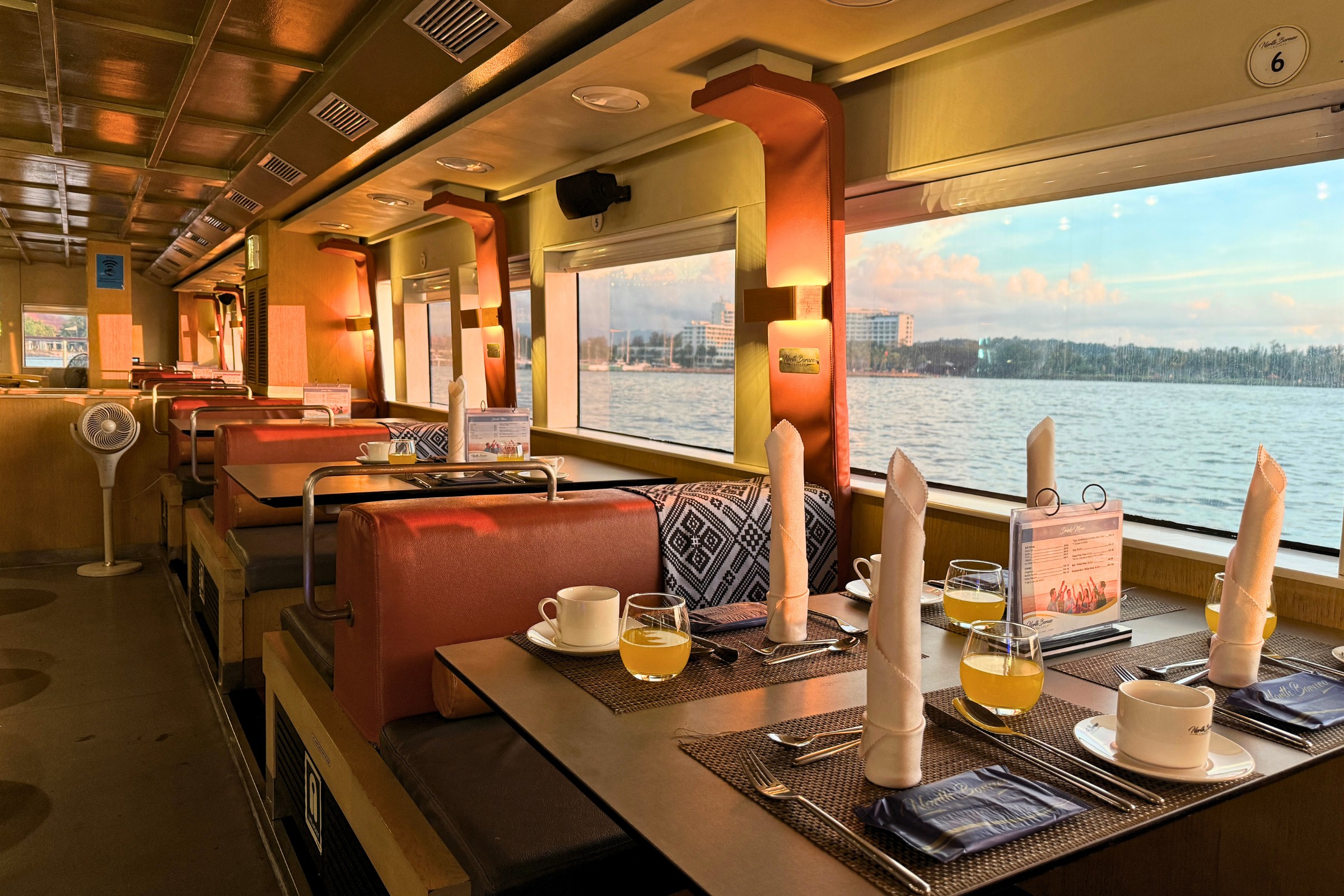 Interior restaurant of North Borneo Cruise with tables and large windows.