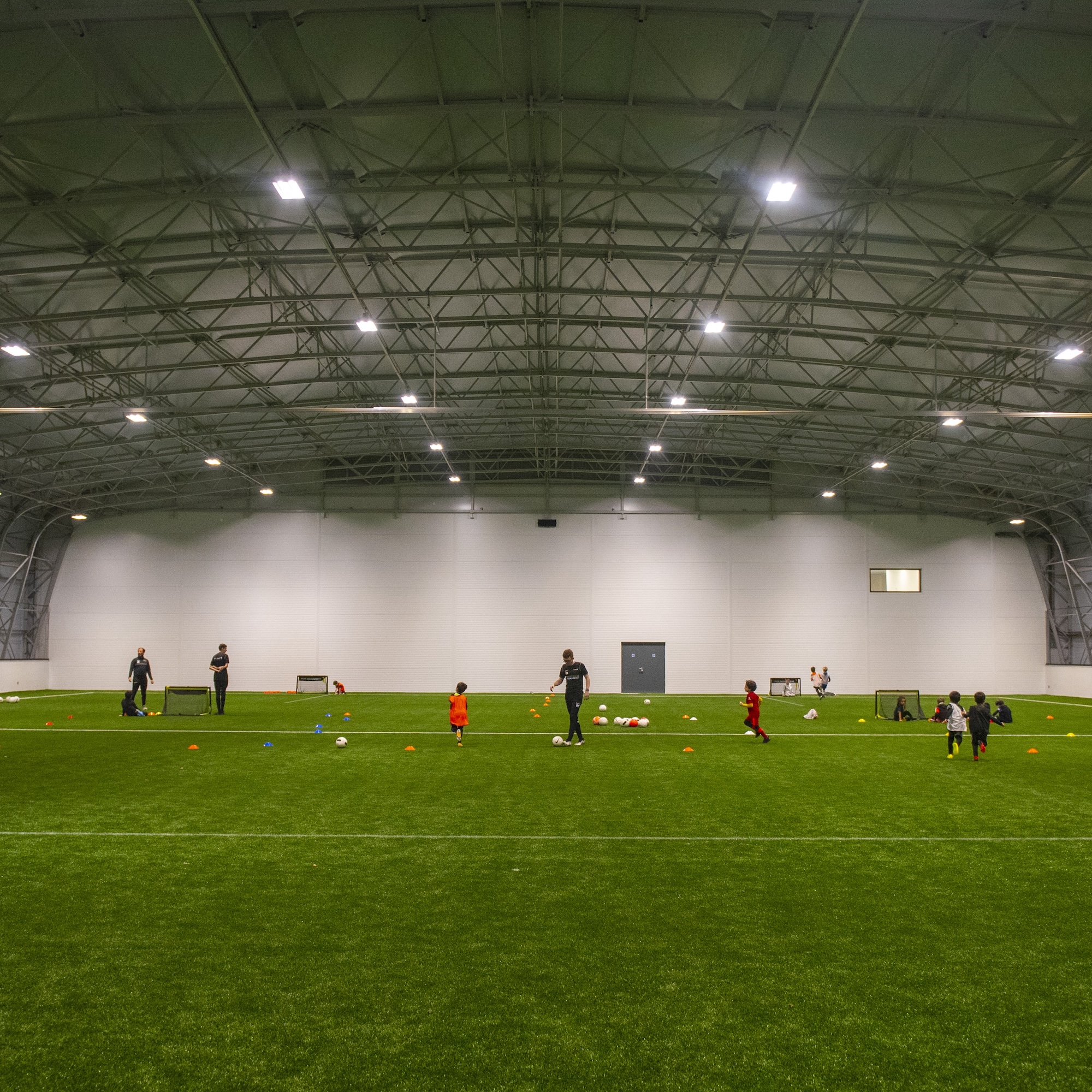 Large indoor football pitch with children playing football