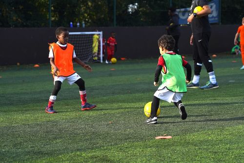 Two children playing a competitive game of football together