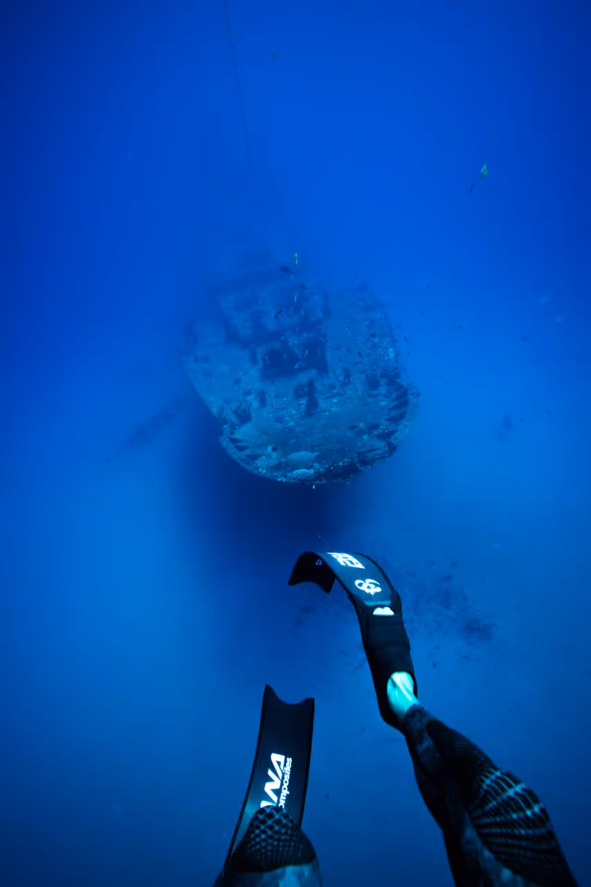 A point-of-view shot overhead of the Sea Tiger Shipwreck in O'ahu with diving fins in the frame. 