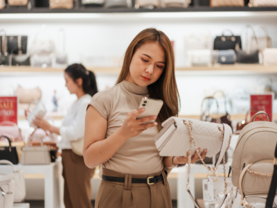 Shopper browsing products on their smartphone while standing in a retail store aisle
