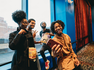Research participant recording a video diary on their smartphone at movies