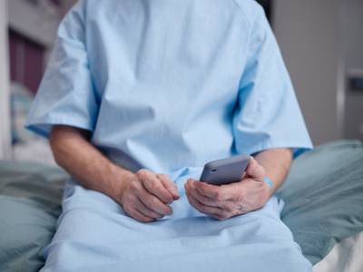 Patient recording a video on their smartphone as part of a healthcare journey mapping study.