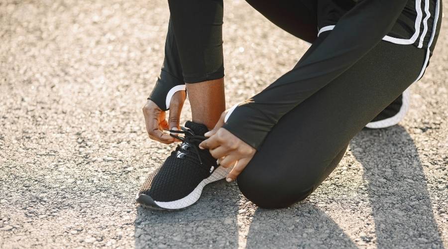 Close up of someone tying their running shoe laces