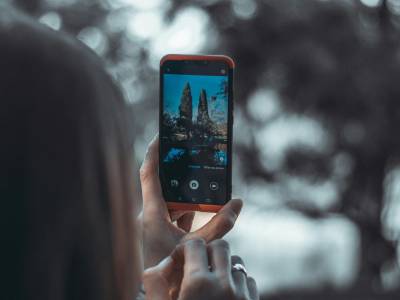 Person taking photo on smart phone.