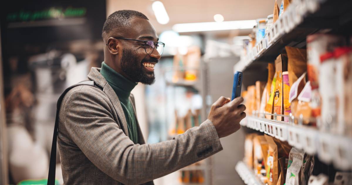 Man recording with smartphone in store.