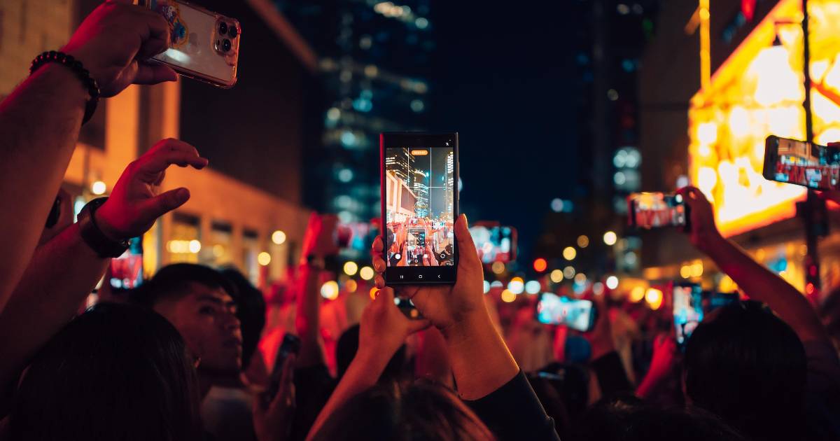 Multiple smartphones recording on street.