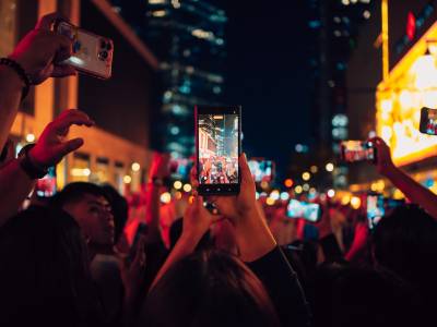Multiple smartphones recording on street.