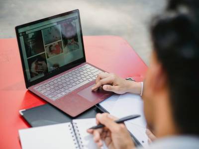 Laptop and Notebooks on Red Table.