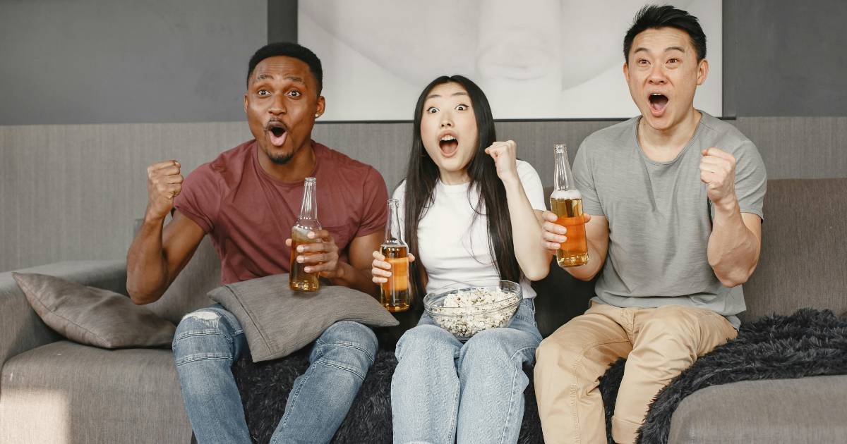 Group of friends watching sport on TV.