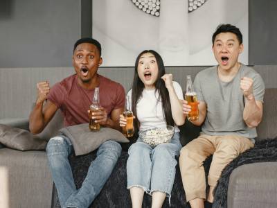 Group of friends watching sport on TV.