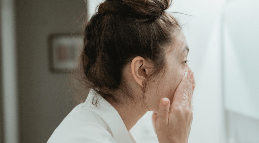 Woman applying skincare.