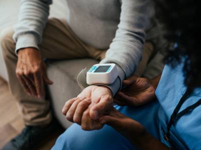 Home medical consultation, elderly person measuring blood pressure