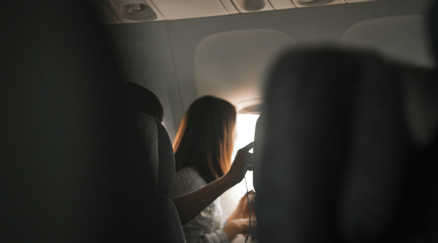 Passenger on plane looking out the window.