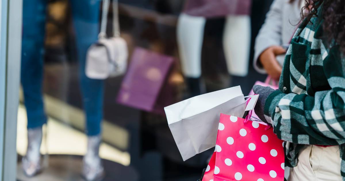 Women with shopping bags standing near counter of shop