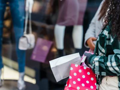 Women with shopping bags standing near counter of shop