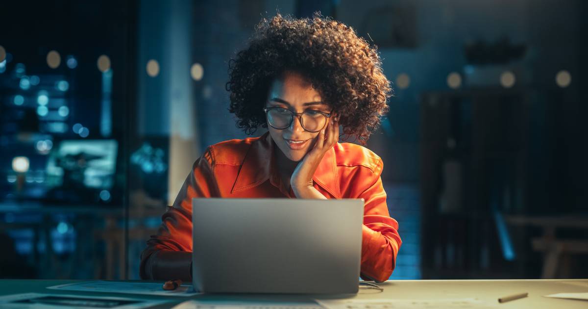 Portrait of a Happy woman Using Laptop Computer in the Evening.