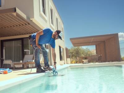 Man cleaning his home pool.