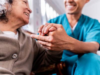 Patient and healthcare worker holding.