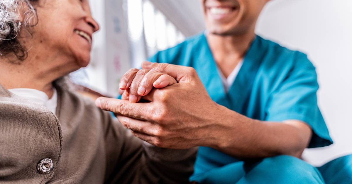 Patient and healthcare worker holding.