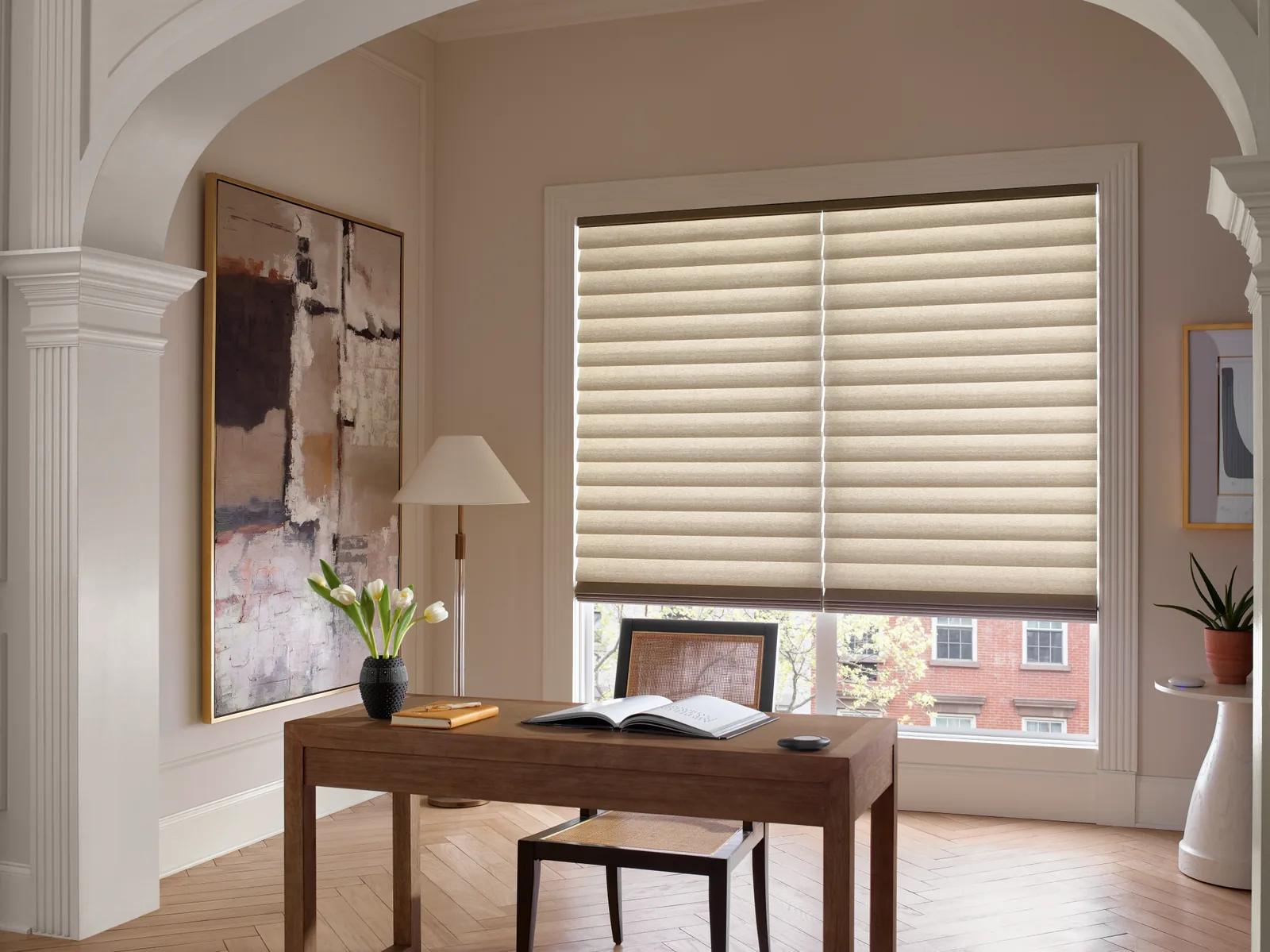 Hunter Douglas Vignette Modern Roman Shades in a warm beige fabric across a large window in a home office