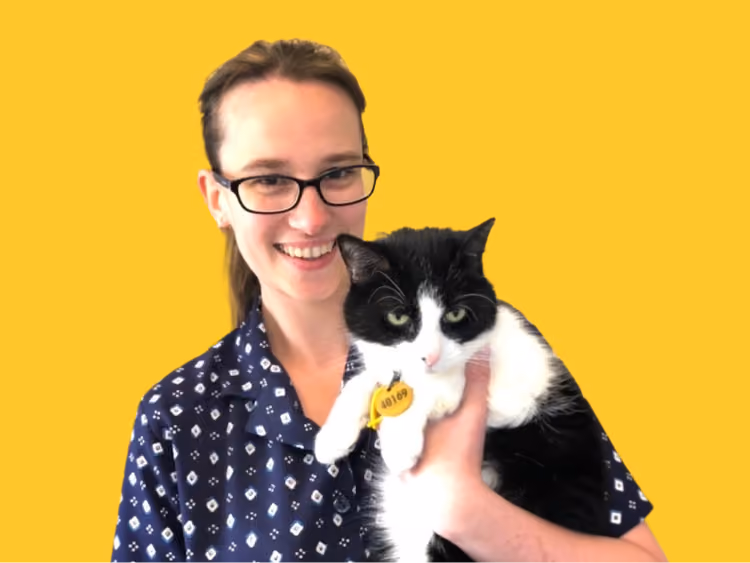 Laura, veterinary nurse at Caring Paws, holding a black and white cat