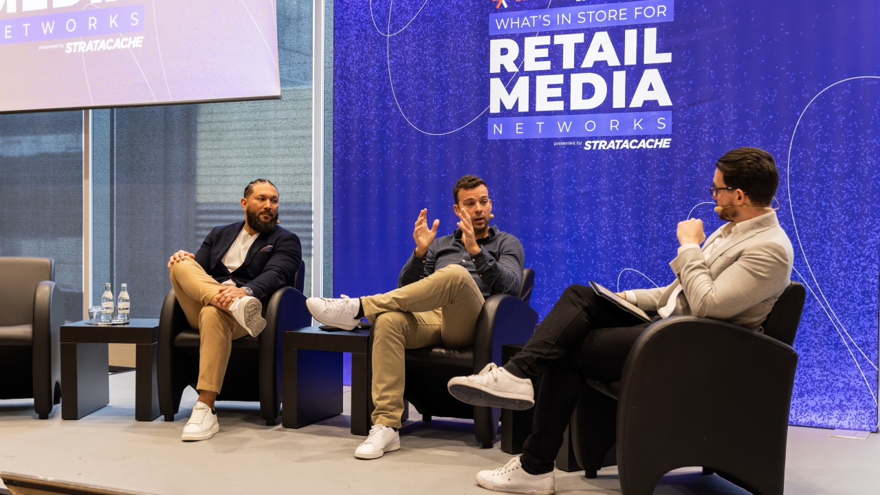 Panel discussion on retail media networks at an industry event with three speakers on stage