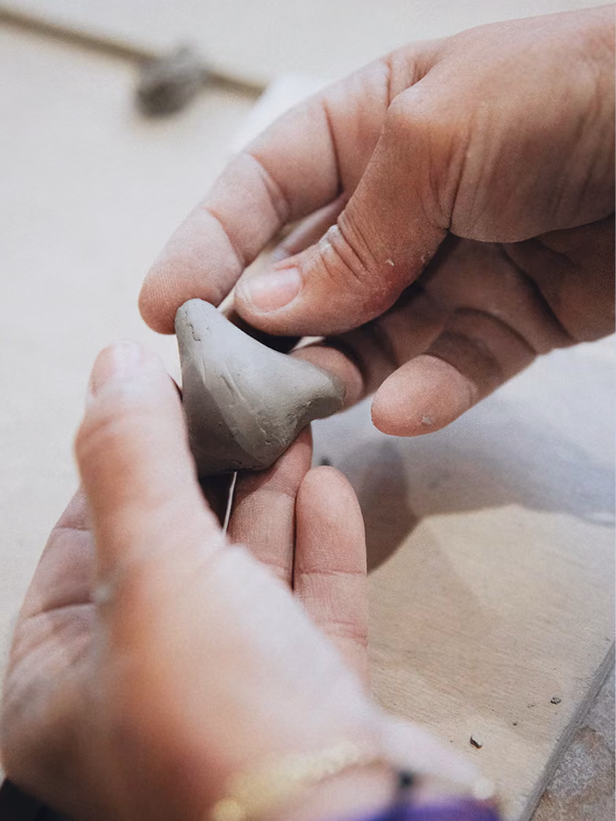 Artisan façonnant un nez en argile