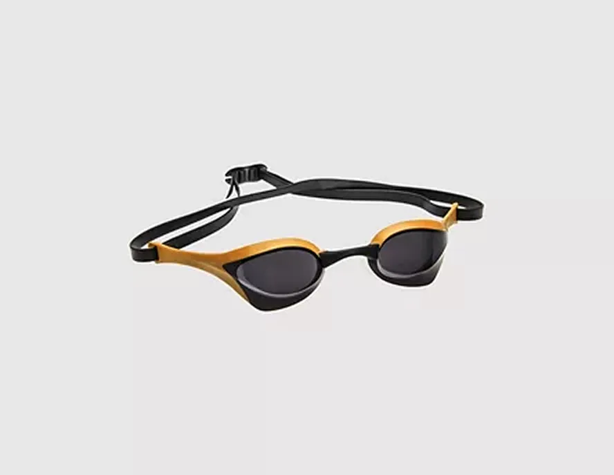 Black and orange swimming goggles with adjustable strap on light background.