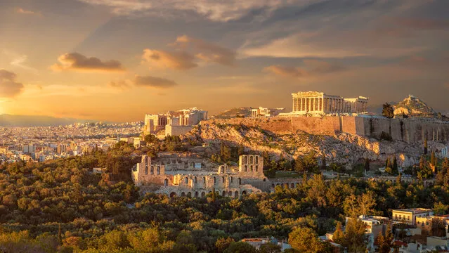 View of the Acropolis of Athens with the Parthenon and Odeon of Herodes Atticus at sunset.