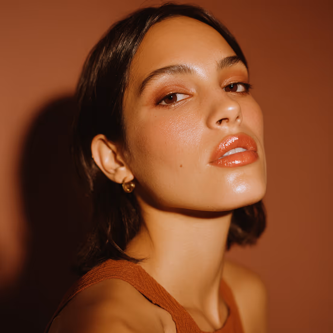 An headshot of a girl with with shrt dark hair and lipstick