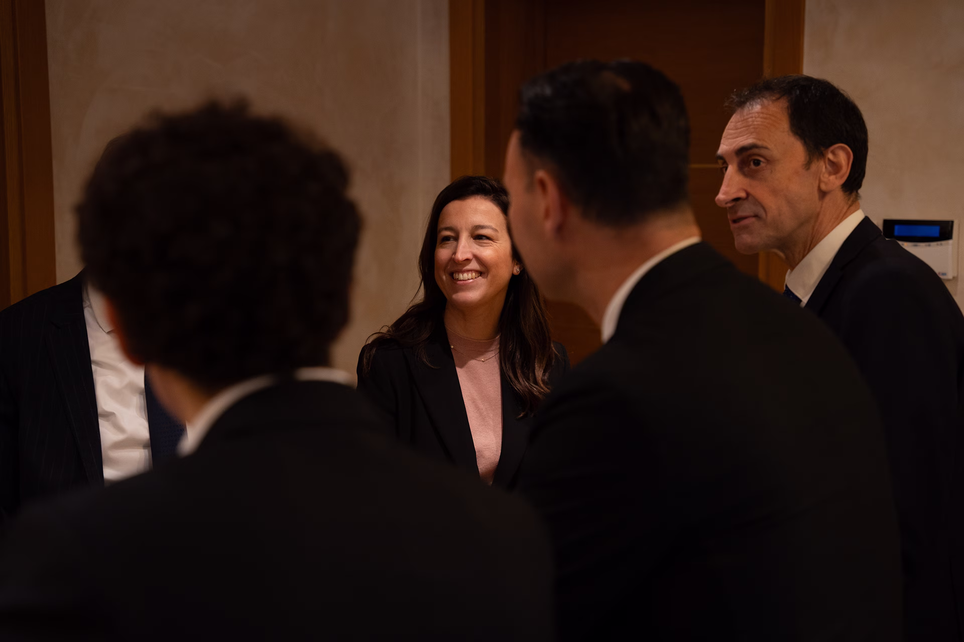 Team di professionisti che collaborano attorno a un tavolo in un luminoso ufficio moderno.