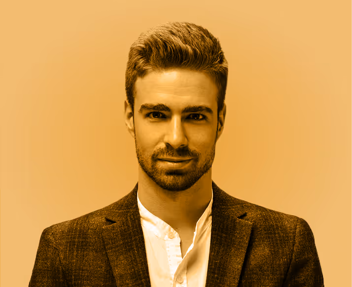 A young man with a beard in a suit on a yellow background
