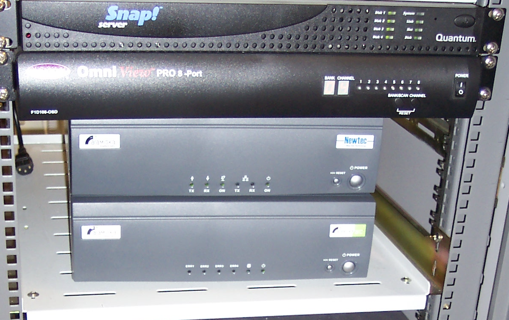 Rack-mounted satellite receiver equipment including Snap! server, Omni View PRO 8-Port, and Newtec units with indicator lights and power buttons.