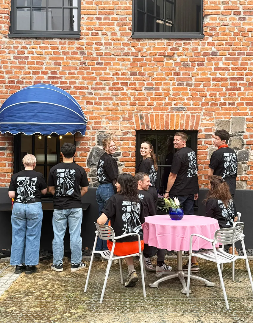 Zwei Männer mit Schürzen schneiden und verarbeiten rohes Hähnchenfleisch in einer Küche.