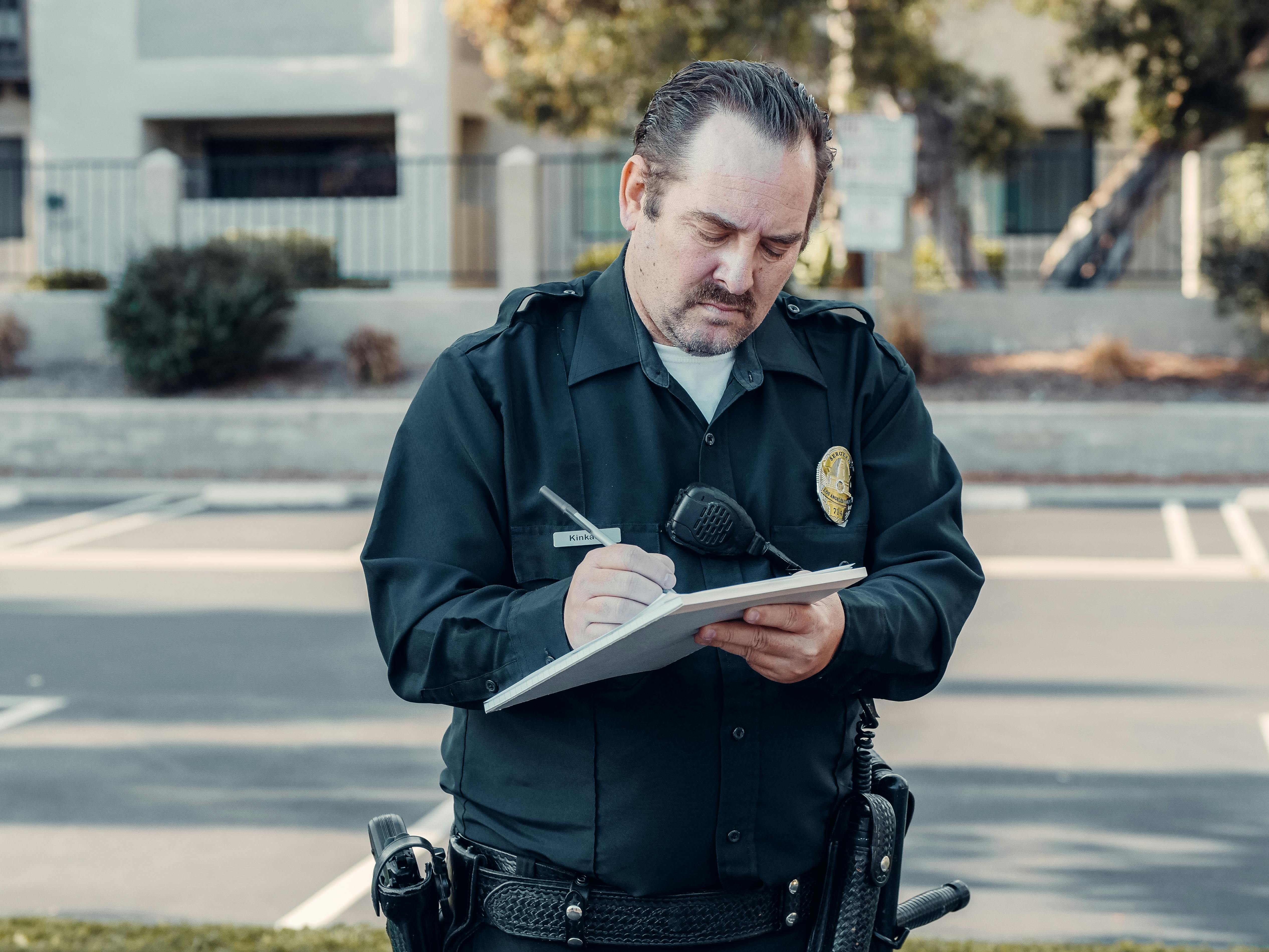 Officer standing at the entrance to a high-risk housing tier, clipboard in hand