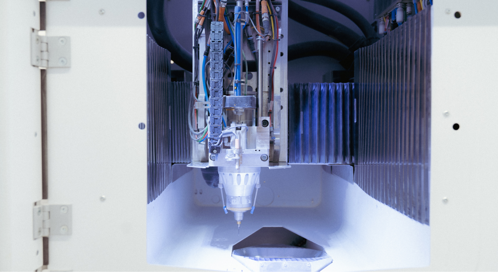 Industrieroboterarm mit verschiedenen Drähten und Mechanismen in einem weißen Maschinengehäuse.