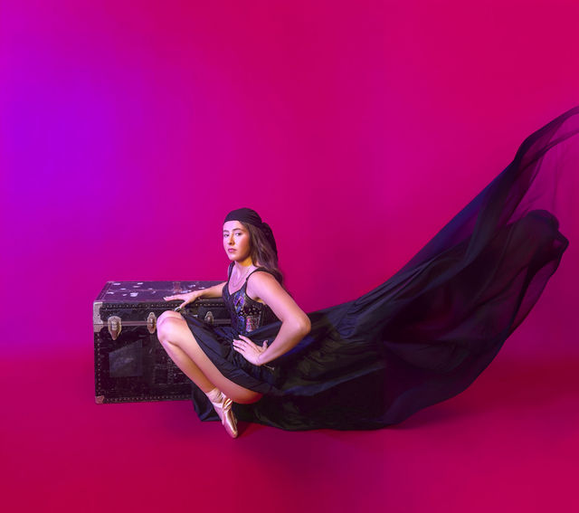 Fashion portrait with flowing fabric and magenta backdrop