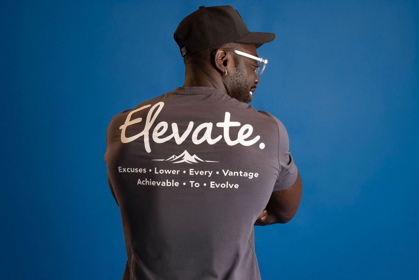 Elevate Company apparel detail against a blue studio backdrop