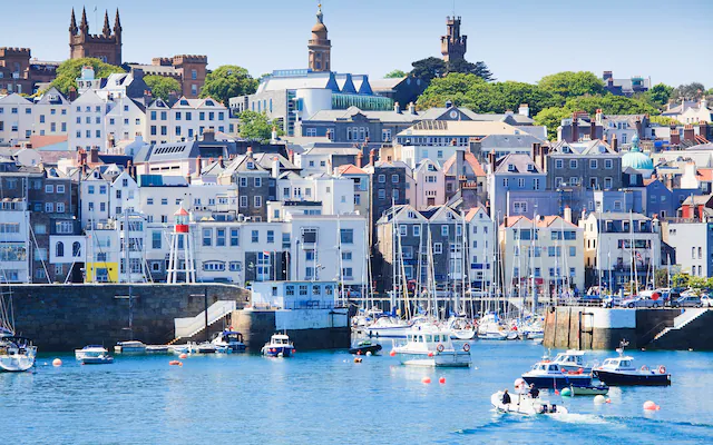 Panoramic view of the St. Peter Port harbor in Guernsey representing its status as a leading offshore financial center for investment funds and wealth management.