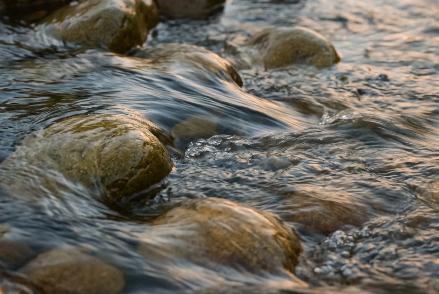 Clear water running over smooth stones in a stream